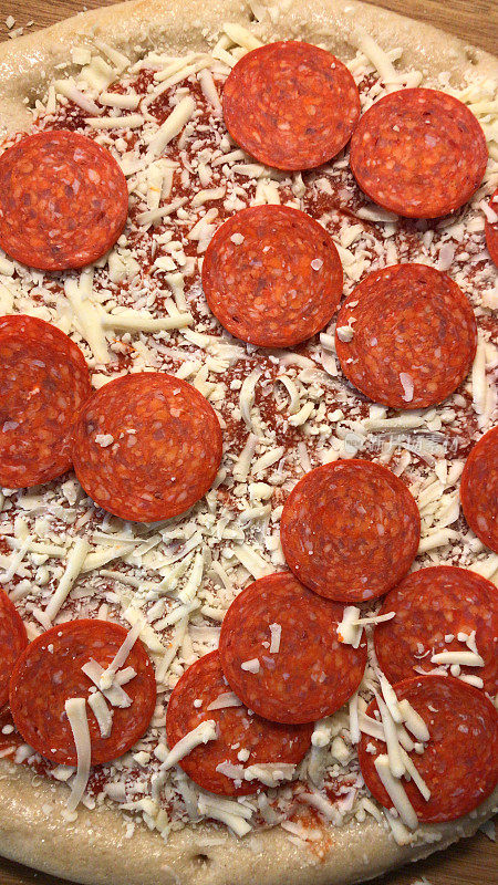 用厨房烤箱烘焙的自制披萨食谱，烤在披萨石上，薄而脆，辣香肠披萨/辣香肠肉盛宴披萨，磨碎的马苏里拉芝士，番茄酱，意大利香草